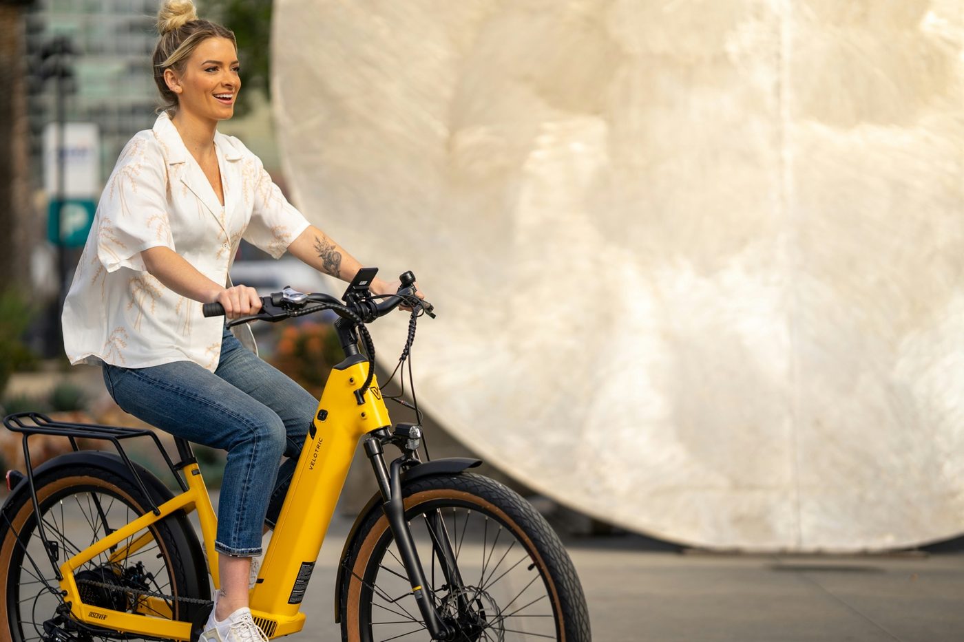 Adult rider on a yellow step-through city e-bike